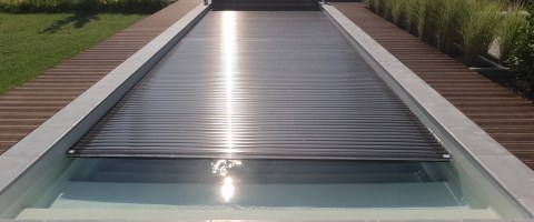 Pool mit geschlossener Rollladen-Abdeckung in modernem Garten