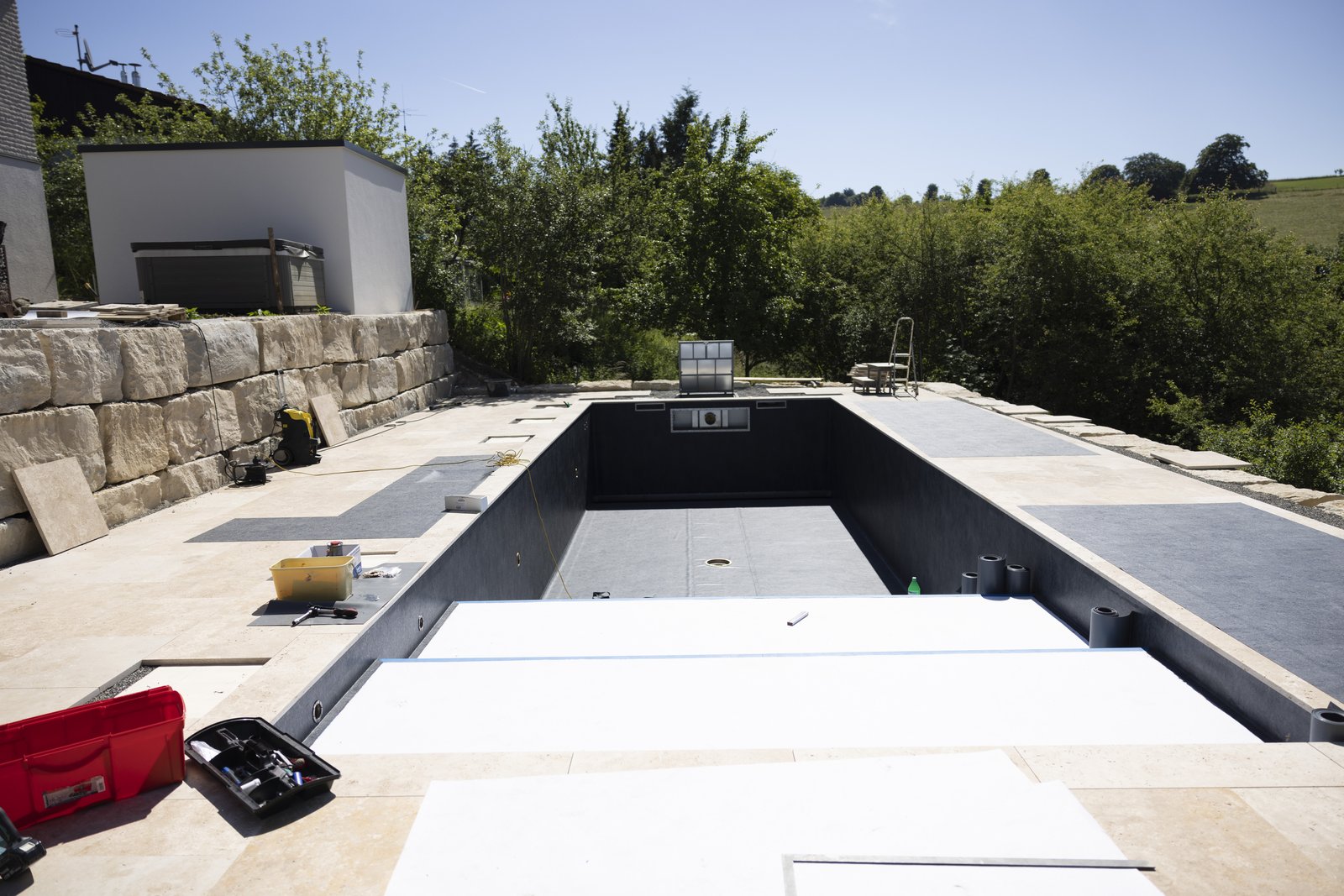 Pool-Rohbau mit Natursteinmauer während einer Schwimmbadbau24-Eigeninstallation auf der Schwäbischen Alb